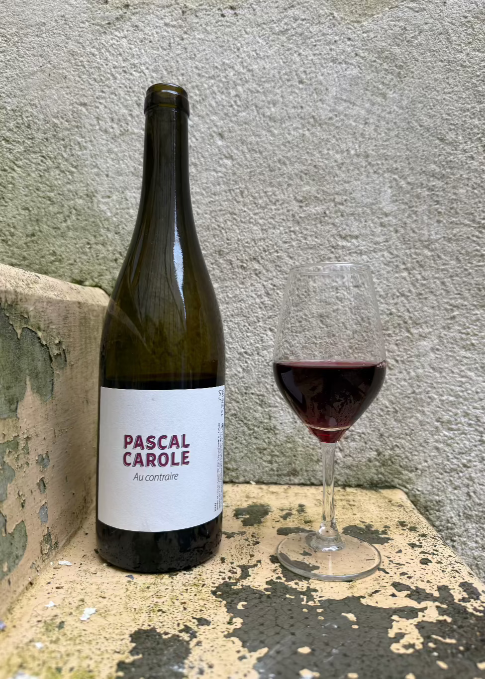 Bottle of Au Contraire wine next to a full glass