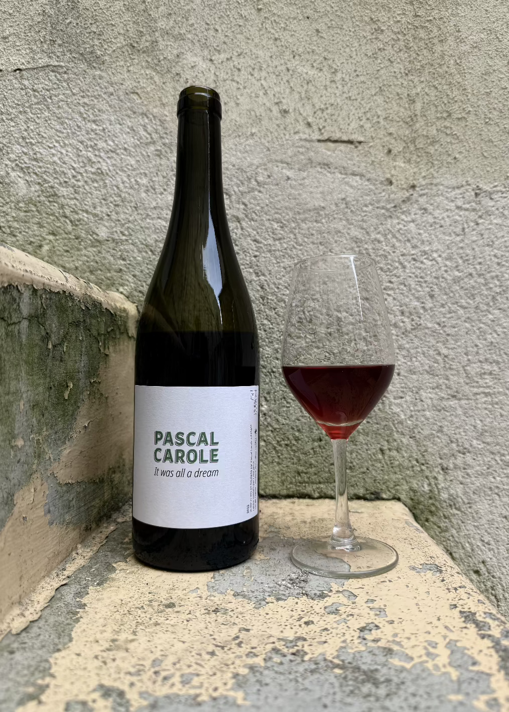 Bottle of It was all a dream wine next to a full glass